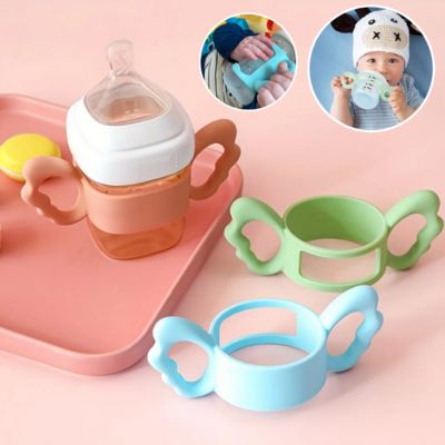 Bébé tenant biberon avec poignée silicone ergonomique autonomie